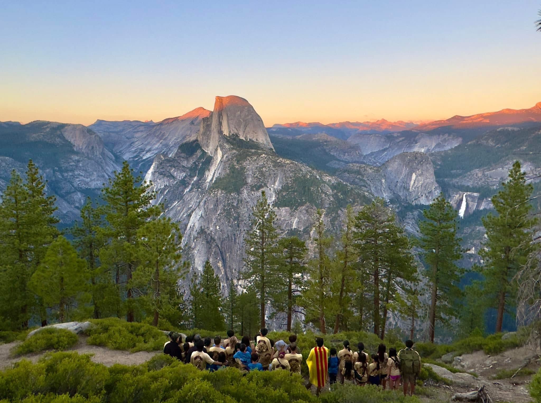 Scouts gathered at Glacier Point at sunset, facing Half Dome