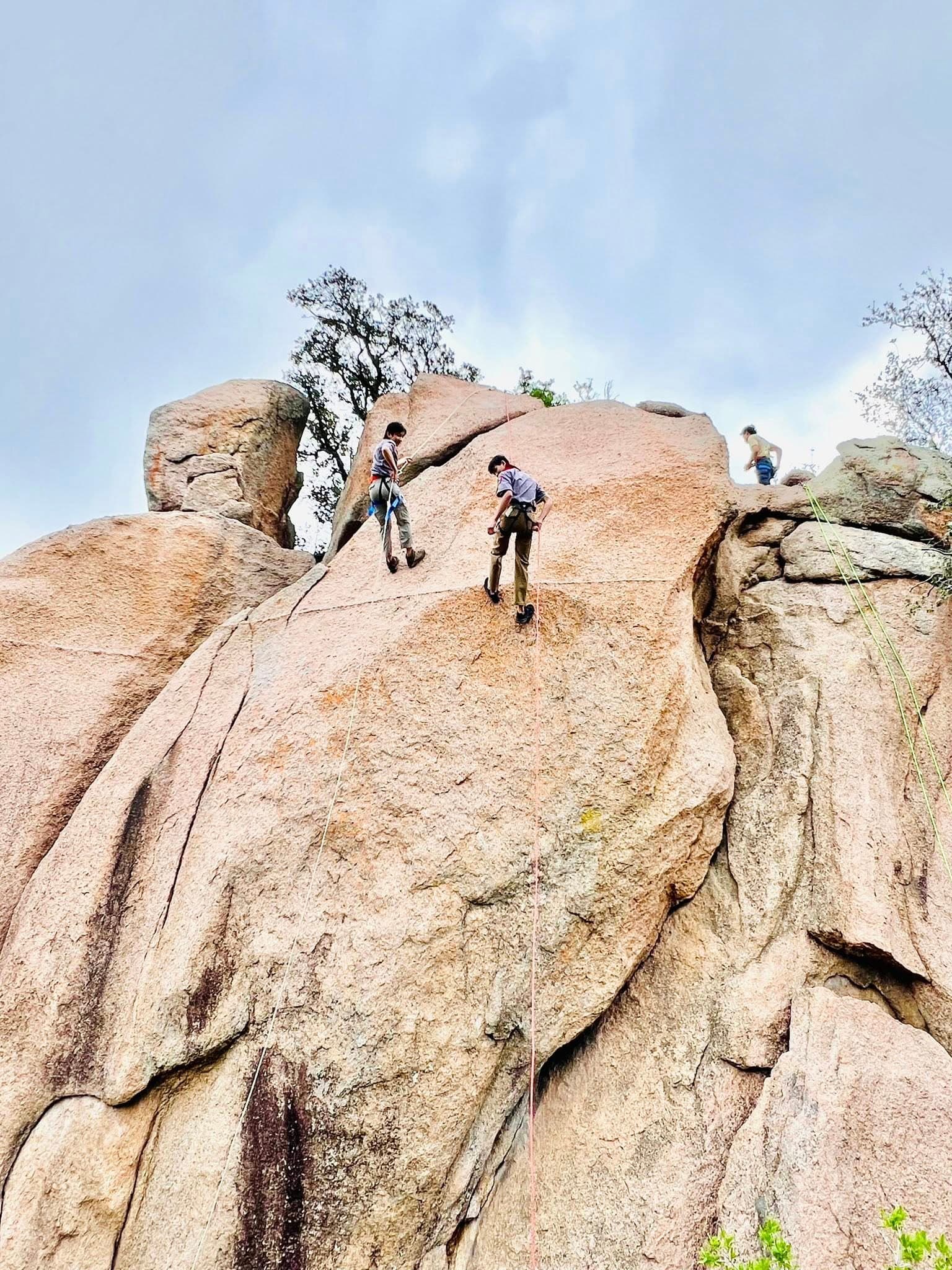A scout climbing a rock face